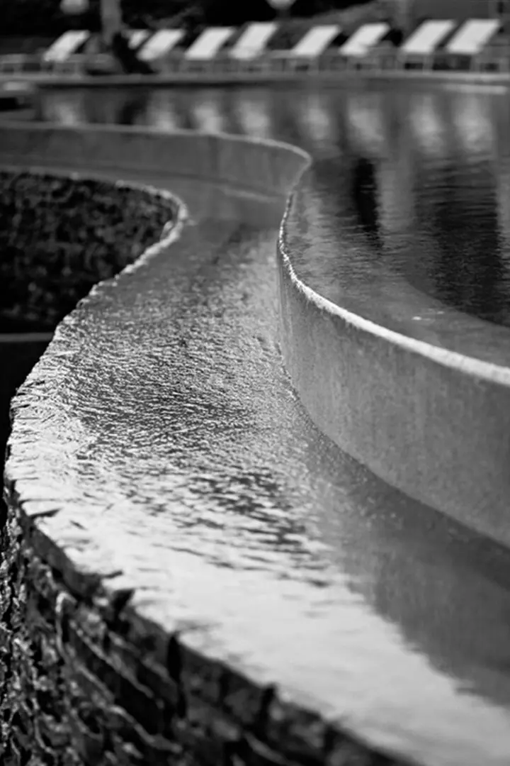 A black and white photo of water flowing over the edge.